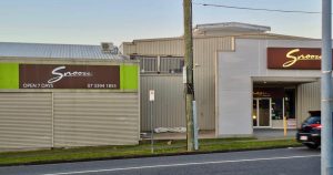 Exterior of a Snooze store with brown and green signage